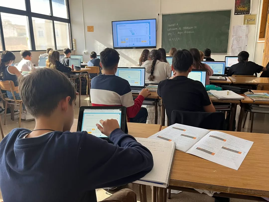 Aula de matemáticas con dispositivos digitales, libro impresa y libreta